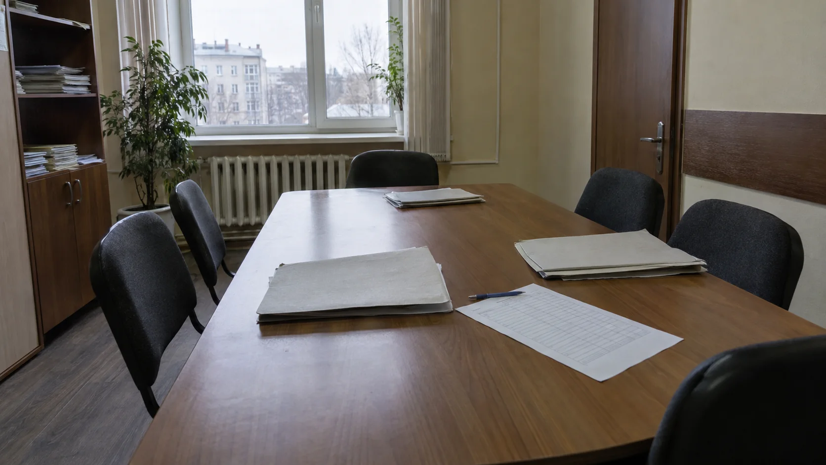 Пустой стол со стульями, папкой и листами для сверки документов собрания кредиторов